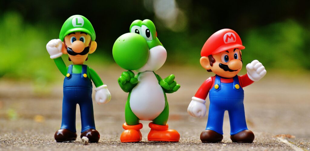 Vibrant Super Mario, Luigi, and Yoshi figures arranged outdoors on a sunny day.